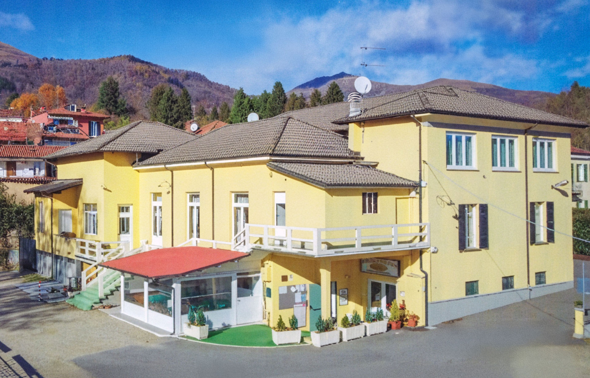 La sede della SOMS Pollone, edificio storico giallo immerso nel paesaggio biellese